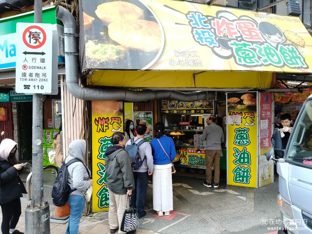 北投炸蛋蔥油餅 北投炸蛋蔥油餅菜單 北投炸蛋蔥油餅推薦 北投區美食 北投美食 最早是以路邊攤車的形式，在北投復興公園泡腳池對面營業，很多人買完會直接走去對面的公園邊，泡腳邊吃，也算是一種固定的北投行程。 @在地老饕阿府