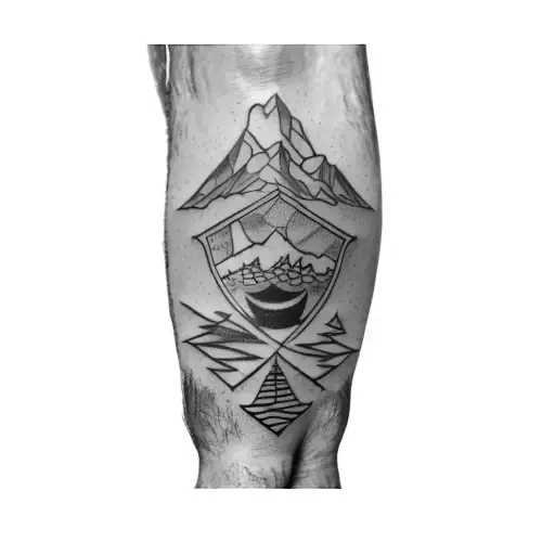 A Man's Leg With A Tattoo Of A Car And Mountains
