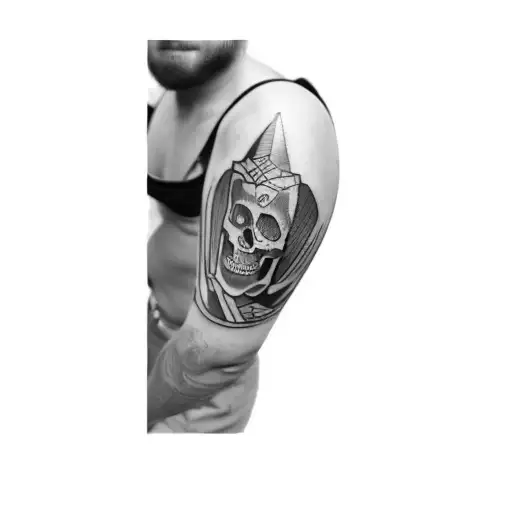 A Man With A Skull Tattoo On His Arm